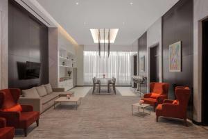利雅德Hyatt Place Riyadh Sulaimania的客厅配有沙发、椅子和桌子