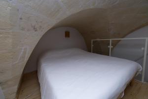 格罗塔列Casa Vacanze Ranieri的卧室配有石墙内的白色床