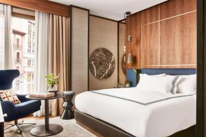 马德里Thompson Madrid, by Hyatt的配有一张床和一把椅子的酒店客房