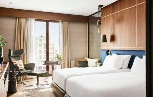 马德里Thompson Madrid, by Hyatt的一间设有大床和窗户的酒店客房