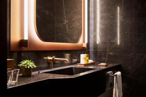 马德里Thompson Madrid, by Hyatt的一间带水槽和镜子的浴室