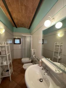 圣吉米纳诺农庄卡萨酒店的浴室设有2个卫生间、水槽和镜子