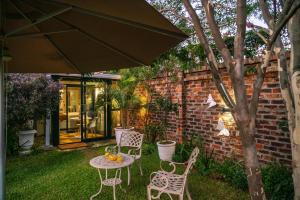 哈拉雷Kamuzi exquisite tiny home near airport - 2217的庭院配有桌椅和遮阳伞。