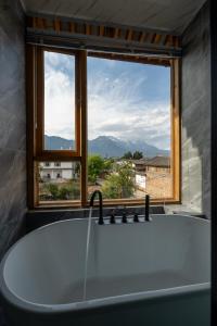 丽江丽江拾田民宿的带浴缸的浴室和窗户