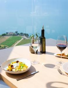 谢布尔Baron Tavernier Hotel Restaurant & SPA的一张桌子,上面放着一盘食物和两杯葡萄酒