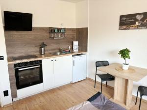 科隆Low Budget Apartment Cologne的厨房配有白色橱柜和带水槽的桌子