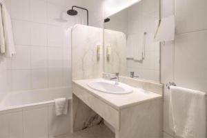 布拉加Hotel Estacão - Braga的白色的浴室设有水槽和淋浴。