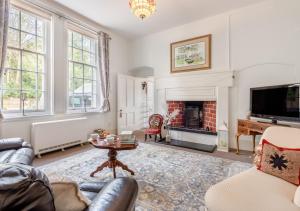 StradsettThe Lake House - Crimplesham Hall的带沙发和壁炉的客厅