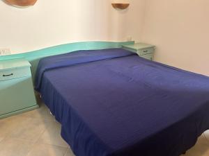 圣阿纳阿雷西Su Nuraghe的一间卧室配有紫色的床和2个床头柜