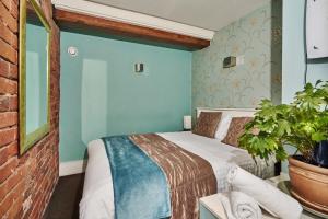 曼彻斯特露诗派得公寓的一间卧室配有一张床和盆栽植物