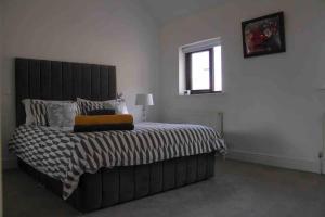 凯尔西温Churchview的一间卧室配有一张带黑色床头板的床和窗户
