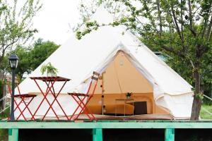 西斯纳迪奥拉Glamping Cisnadioara的一个带椅子和桌子的白色帐篷