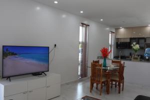 Long Bay HillsOcean Pearl - Getaway Holiday home的客厅配有电视和桌椅