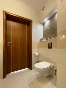 米兹多洛杰Apartment Platinum的一间带卫生间和木门的浴室