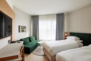 库雷萨雷乔治奥特斯温泉酒店的酒店客房,设有两张床和一张绿色沙发