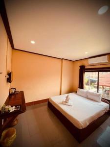 万荣ViengSaVanh Hotel的一间卧室设有一张大床和一个窗户。