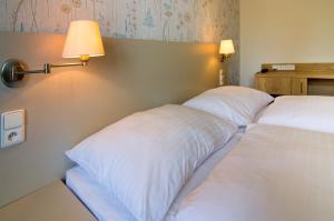 斯尼Hotel Srní的配有白色枕头的酒店客房内的两张床