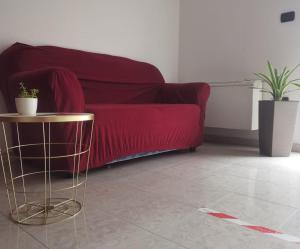 Laino BorgoHotel Edelweiss的客厅配有红色的沙发和桌子