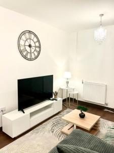 梅德斯通Captivating 2-Bed Apartment in Maidstone的客厅配有大电视和墙上的时钟