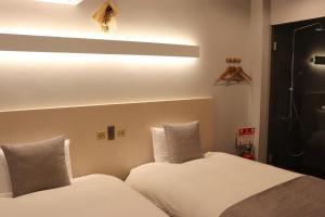 京都ホテル SHUNJU Dosse 1日1組様限定的一间卧室配有两张带白色床单的床