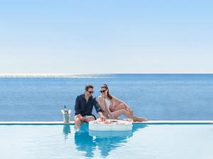 拉卡尼亚泰拉索温泉度假&中庭名誉别墅酒店的坐在游泳池里的男人和女人
