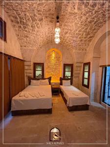 尚勒乌尔法Serce Konagi的一间卧室设有两张床和石墙