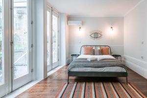 波尔图GuestReady - Bourse Maison的一间卧室设有一张床和一个大窗户