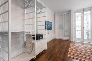 波尔图GuestReady - Bourse Maison的一间设有白色架子和电视的房间