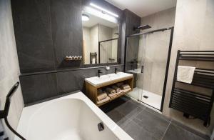 杰多维尼切Hotel Kras的带浴缸、水槽和镜子的浴室
