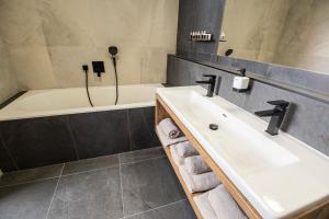 杰多维尼切Hotel Kras的浴室配有盥洗盆和浴缸。