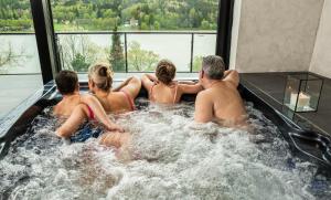 杰多维尼切Hotel Kras的一组坐在热水浴缸中的人