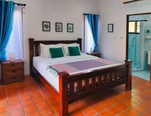 乔木提恩海滩4 Bed Villa Private Pool and BBQ Jomtien Beach的一间卧室配有一张带绿色枕头的木床。