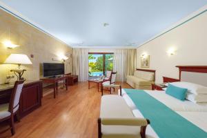 卡拉索斯中庭宫殿水疗生活别墅度假酒店的酒店客房设有一张大床和一台电视。