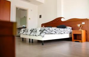 佩斯基奇Max Luxury Suite - Servizio Spiaggia Inclusa的一间卧室配有一张带木制床头板的床