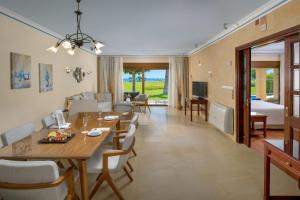 卡拉索斯中庭宫殿水疗生活别墅度假酒店的用餐室以及带桌椅的起居室。