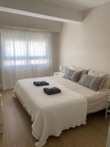 瓦伦西亚Apartamento centrico familiar en Valencia( Frente Estacion Ave ,Joaquin Sorolla)的一间白色卧室,在大床上配有2条毛巾