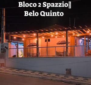 布罗塔斯Brotas Suítes Belo Quinto & Spazzio Bloco 2的一座带露台的建筑,配有桌子和遮阳伞