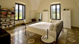 法萨诺Masseria Celeste的卧室配有床、镜子和窗户。