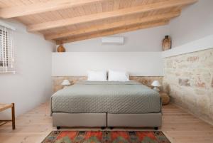 阿卡尼斯The Olive Grove Cottage with private swimming pool的一间卧室设有一张床和木制天花板