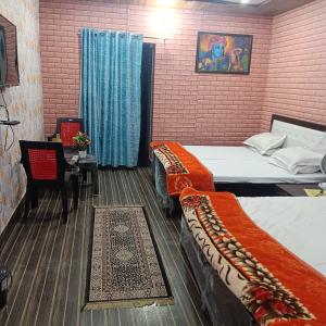 范兰德凡Somnath residency的客房设有两张床和一张桌子及椅子