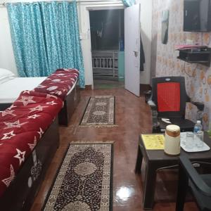 范兰德凡Somnath residency的客房设有床、沙发和桌子。