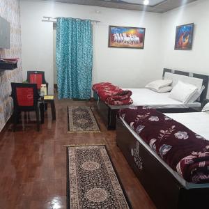 范兰德凡Somnath residency的一间设有两张床、一张桌子和一把椅子的房间