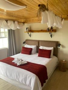 坎波斯杜若尔当Pousada Ville Le Mont的卧室配有带红色枕头的大型白色床