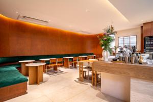 曼谷Saan Hotel Sathorn的餐厅拥有木墙和木桌及椅子
