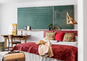 维也纳斯塔德尔精品酒店的一间卧室配有红色的床和绿色的粉笔板