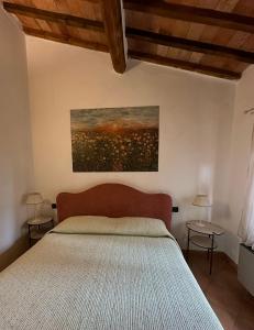 圣吉米纳诺农庄卡萨酒店的卧室配有一张床,墙上挂有绘画作品