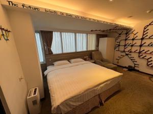 台北RF富裕自由旅店 - 林森馆的卧室配有一张挂有墙上标志的床