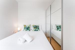 波尔图GuestReady - Camões Refuge的白色卧室配有床和镜子