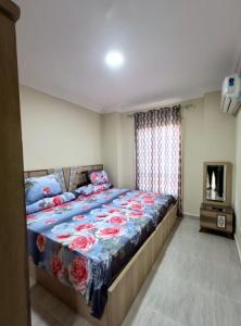 艾因苏赫纳LASIRENA PALM BEACH RESORT -FAMILY的一间卧室配有一张带蓝色棉被的床和一个壁炉