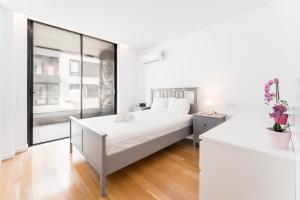 加亚新城GuestReady - Amazing Modern home near the beach的白色的卧室设有一张大床和一个窗户